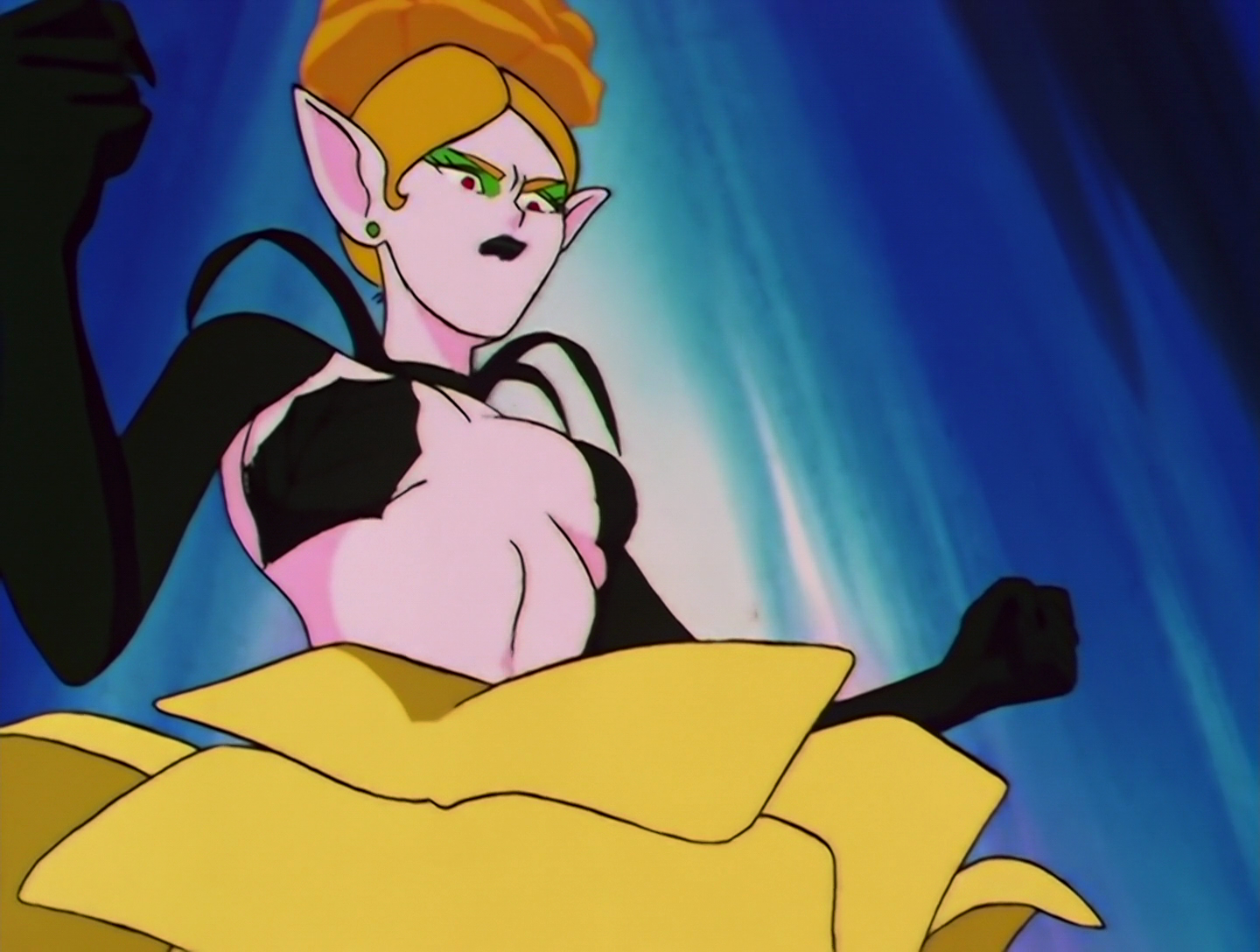 U-Baulla, a Daimon from Sailor Moon episode 116. She has pale pink skin, green eyeshadow and black lipstick. She has black sleeves and a barely adequate top that looks like two plant leaves. Her hair is yellow-orange and she has a rose on her head, and another large yellow rose as a skirt.